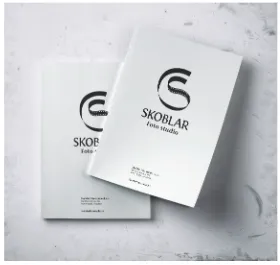 Two white photo folders with the monogram and studio name